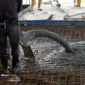 Construction worker pouring concrete for a building floor slab